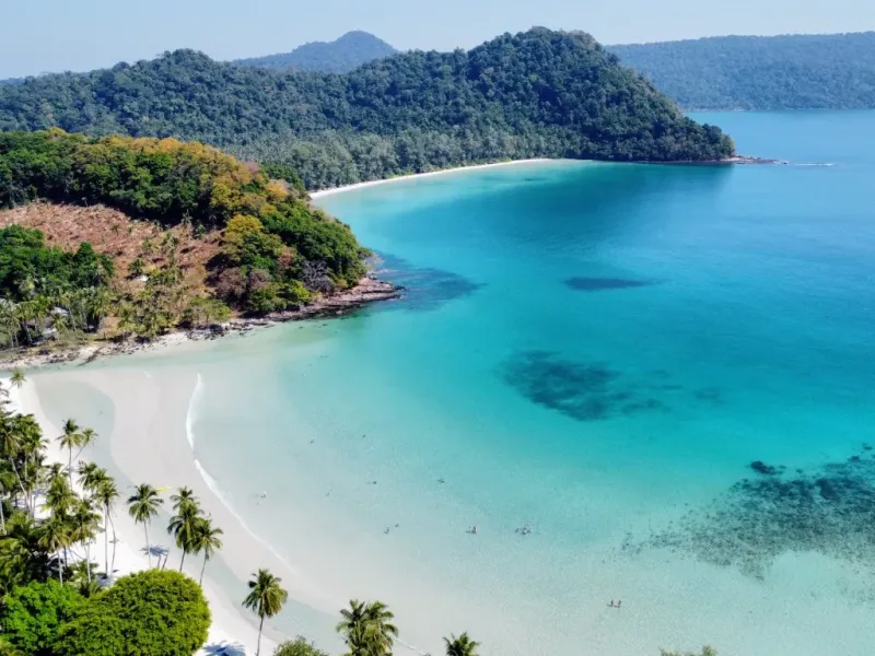 Traditionelles thailändisches Holzboot an einem türkisblauen Traumstrand in Krabi, Thailand